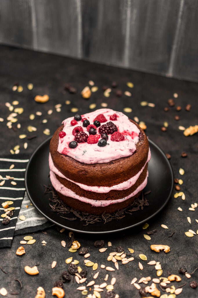 Rich chocolate vegan cake topped with berry frosting and nuts -vegan cake delhi 